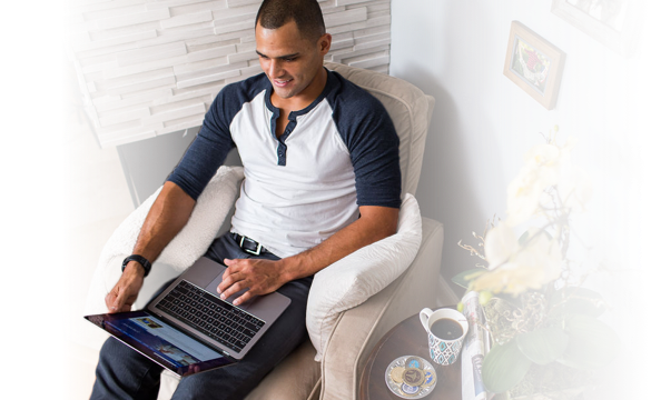 Civilian male sitting on chair looking at laptop